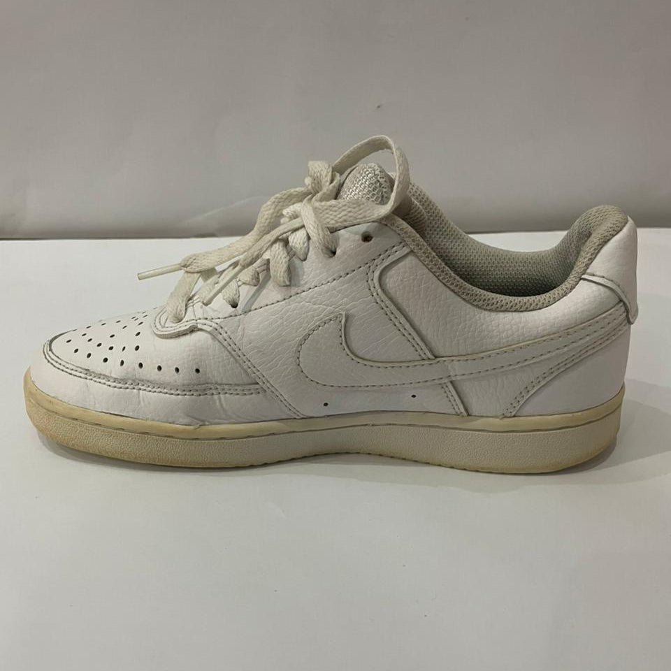 Beige sneaker with Nike logo on a light gray background